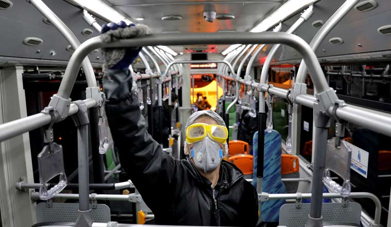 A worker disinfects a public bus against coronavirus in Tehran, Iran | AP