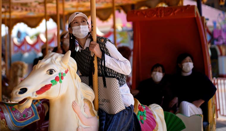 People wearing face masks are seen at the Happy Valley amusement park in Shanghai on its first day of opening after the COVID-19 outbreak | Reuters