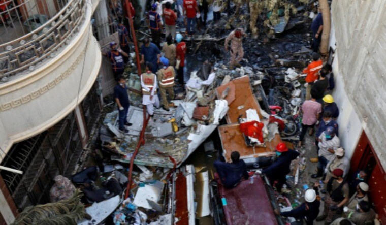 Rescue workers gather at the site of the PIA passenger plane crash in a residential area in Karachi | Reuters