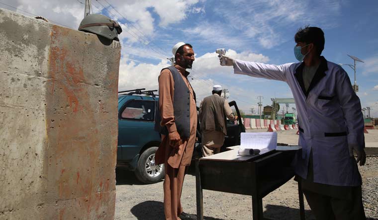 A health worker checks the temperature of car passengers in an effort to help stop the spread of the coronavirus, as they enter the city in the Paghman district of Kabul, Afghanistan, Sunday, May 3, 2020 | AP Photo/Rahmat Gul