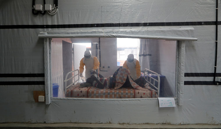 Moise Vaghemi, 33, (L) an Ebola survivor who works as a nurse cares for a patient who is suspected to be suffering from Ebola, inside the Biosecure Emergency Care Unit (CUBE) at the Ebola treatment centre in Katwa, near Butembo, in the Democratic Republic of Congo, October 3, 2019 | REUTERS/Zohra Bensemra/File Photo