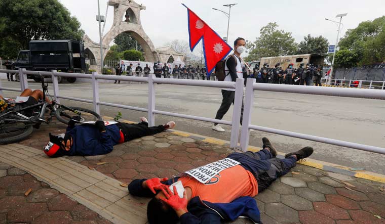 Protesters lie on the ground demanding better handling of the COVID-19 pandemic in Kathmandu | AP