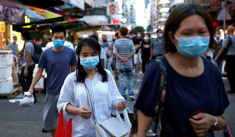 People, wearing surgical masks, at a wet market at Sham Shui Po in Hong Kong | Reuters