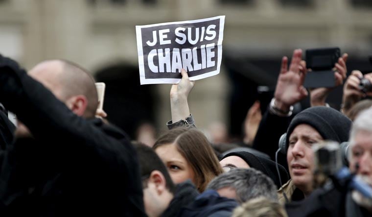  A person holds up a "Je Suis Charlie" (I am Charlie) sign during a ceremony at Place de la Republique to pay tribute to the victims of last year's shooting at the French satirical newspaper Charlie Hebdo, in Paris, France, January 10, 2016 | REUTERS/Yoan Valat/Pool/File Photo