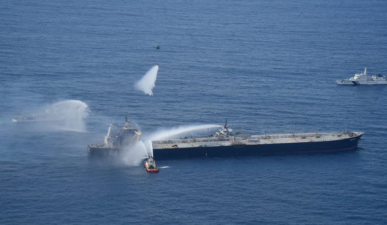 A Sri Lankan Navy boat sprays water on the New Diamond, a very large crude carrier (VLCC) chartered by Indian Oil Corp (IOC), that was carrying the equivalent of about 2 million barrels of oil, after a fire broke out off east coast of Sri Lanka September 6, 2020 | Sri Lankan Airforce media/Handout via REUTERS