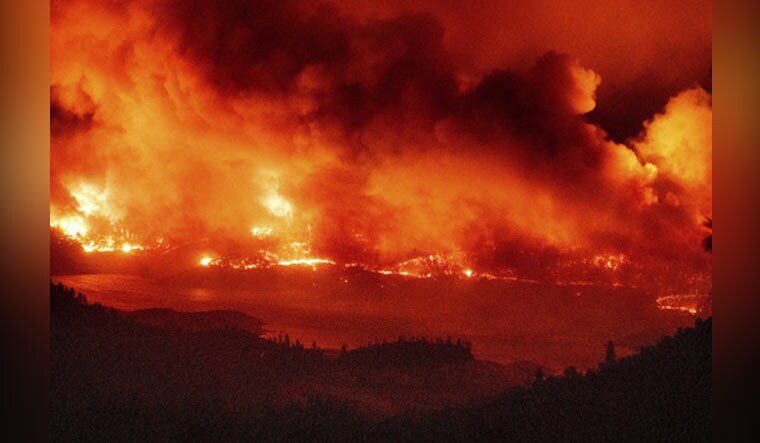 Flames lick above vehicles on Highway 162 as the Bear Fire burns in Oroville, Calif., on Wednesday, Sept. 9, 2020. The blaze, part of the lightning-sparked North Complex, expanded at a critical rate of spread as winds buffeted the region | AP
