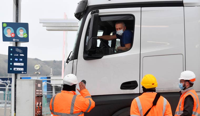A lorry driver shows documentation to officials for both customs clearance and coronavirus disease (COVID-19) test results as he arrives at the Eurotunnel on route to France on the first day after the end of the Brexit transition period, Folkestone, Britain, January 1, 2021 | Reuters