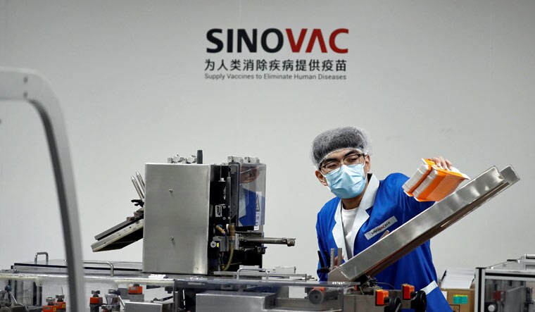 A man works in the packaging facility of Chinese vaccine maker Sinovac Biotech | Reuters