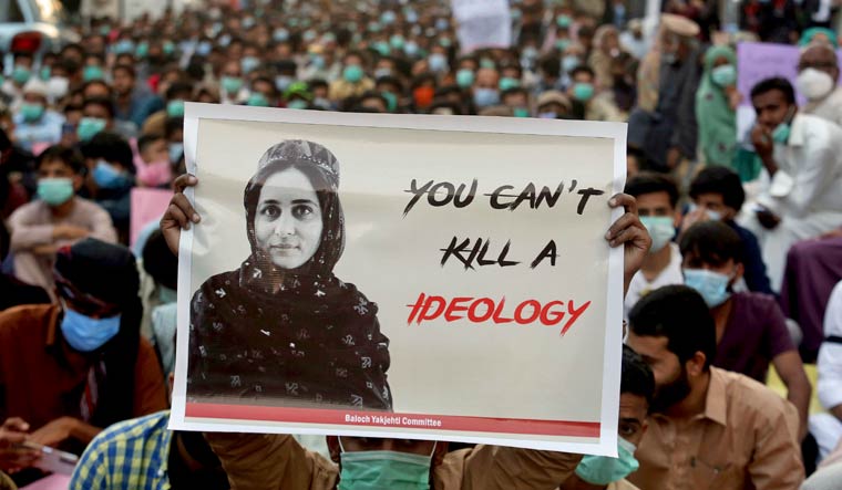 FILE - In this Dec. 24, 2020, file photo, supporters of Baloch political activist Karima Baloch hold her portrait during a demonstration to condemn her killing, in Karachi, Pakistan. | AP Photo/Fareed Khan, File

