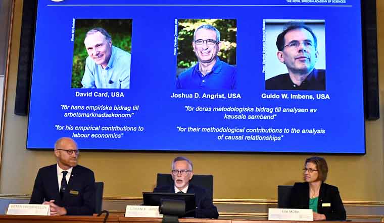 Stockholm: Permanent Secretary of the Royal Swedish Academy of Sciences Goran K Hansson, center, announces the 2021 Nobel prize for economics. From left on the screen above are the winners David Card of the University of California at Berkeley; Joshua Angrist from the Massachusetts Institute of Technology; and Guido Imbens from Stanford University | AP/PTI

