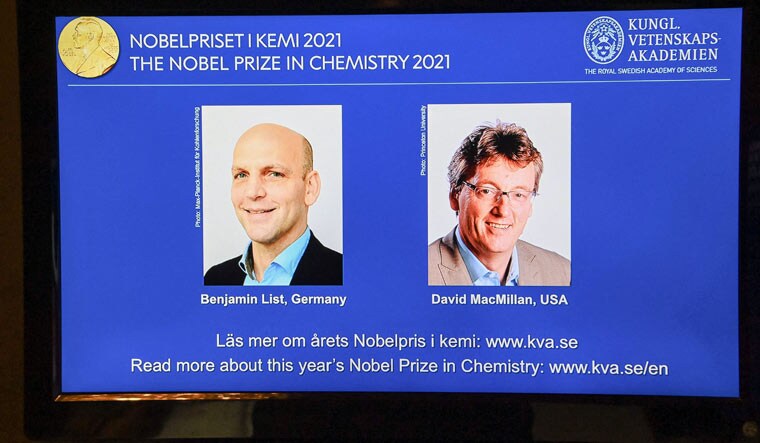 A screen displays the co-winners of the 2021 Nobel Prize in Chemistry, Germany's Benjamin List (L) and David MacMillan of the United States | AFP