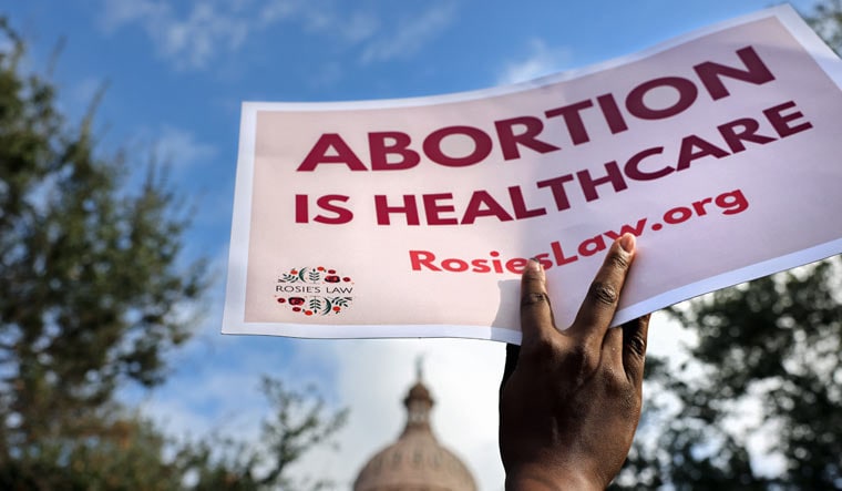 A supporter of reproductive rights holds a sign outside the Texas State Capitol building during the nationwide Women's March, held after Texas rolled out a near-total ban on abortion procedures and access to abortion-inducing medications, in Austin, Texas, US October 2, 2021 | Reuters