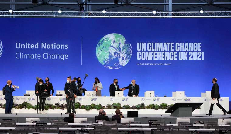 COP26 President Alok Sharma, behind stage chairs second right,  gets ready for the start of a stocktaking plenary session at the U.N. Climate Summit in Glasgow, Scotland | AP