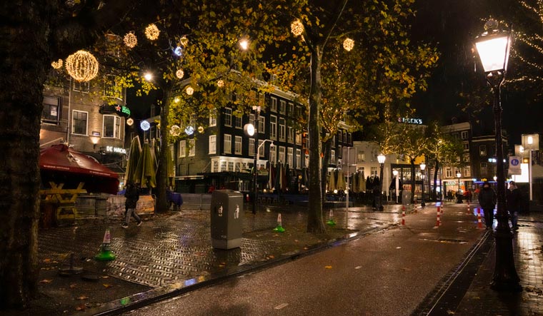 Closed bars and restaurants under a partial lockdown in a near-deserted Rembrandt plein, or Rembrandt Square, in Amsterdam, Netherlands, Friday, Nov. 26, 2021 | AP

