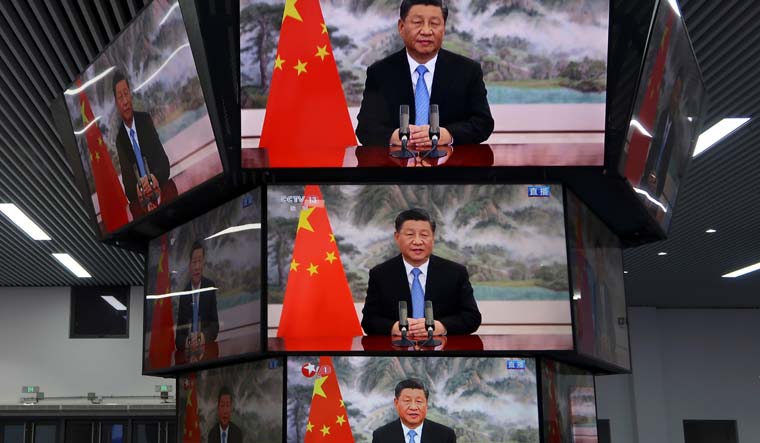 Chinese President Xi Jinping is seen on television screens during his speech on November 4 | Reuters