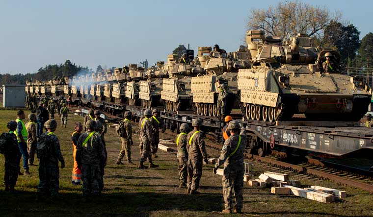 FILE - US Army personnel prepare to unload Bradley Infantry Fighting Vehicles from rail cars as they arrive at the Pabrade railway station some 50 km (31 miles) north of the capital Vilnius, Lithuania, Oct. 21, 2019 | AP