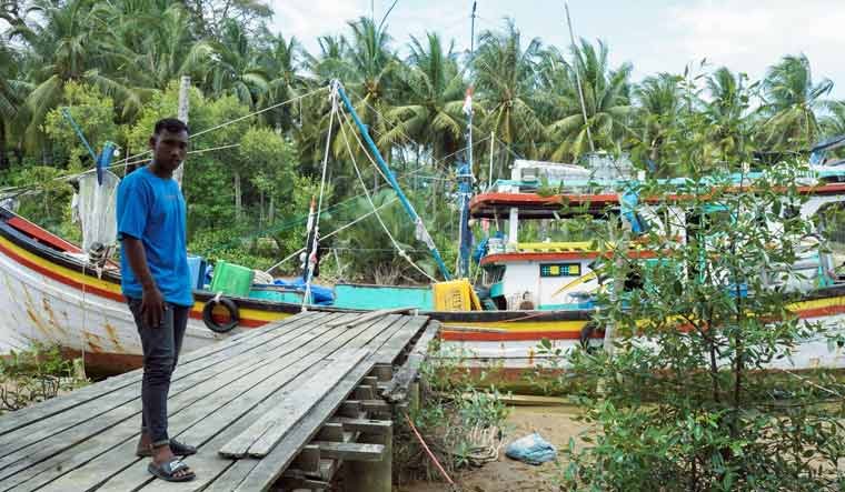 Local fisherman Aditya Setiawan, 20, poses near his wooden boat during an interview as a witness, following a boat carrying Rohingya refugees being stranded at sea off the coast of Bireuen, Aceh province, Indonesia, December 29, 2021 | Reuters