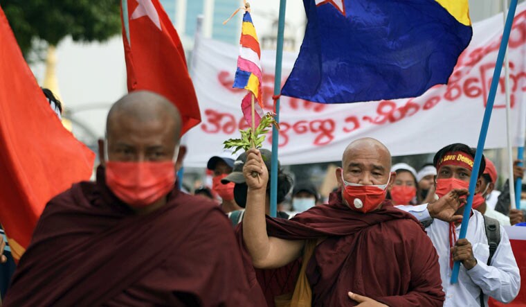 A Buddhist monk holds a flag during a protest against the military coup in Yangon, Myanmar | Reuters