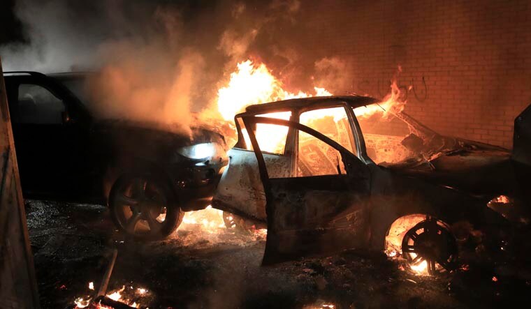 Hijacked cars burn at the peace wall on Lanark Way as rioting broke out in West Belfast, Northern Ireland | AP