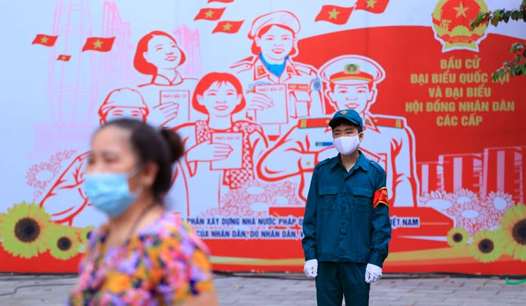 A masked security person guards outside a polling station in Hanoi, Vietnam Sunday, May 23, 2021. Vietnamese cast their ballots to elect 500 delegates for a five-year term at the National Assembly, Vietnam's legislative body, as the country is combating a new wave of COVID-19 | AP