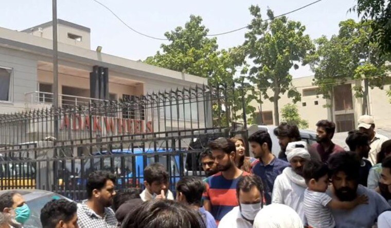 People gather outside a damaged shop after an explosion in Lahore, Pakistan | Twitter  