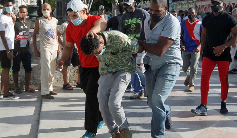 Plain clothes police detain a person during protests against and in support of the government, amidst the coronavirus disease (COVID-19) outbreak, in Havana, Cuba | Reuters