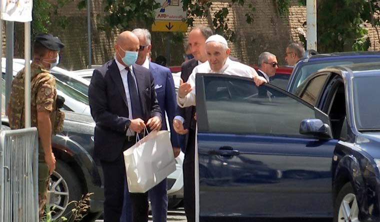 Pope Francis leaves the car to greet policemen before entering the Vatican after being discharged from Gemelli hospital | Reuters
