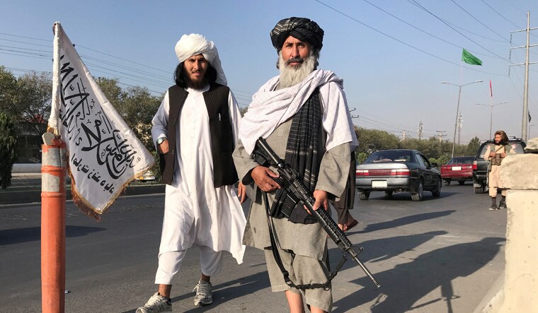 Taliban fighters stand outside the interior ministry in Kabul, Afghanistan | Reuters