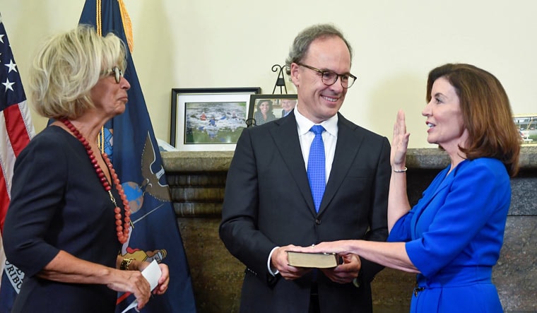 New York Chief Judge Janet DiFiore, left, swears in Kathy Hochul, right, as the first woman to be New York's governor while her husband Bill Hochul holds a bible during a swearing-in ceremony in the Red Room at the state Capitol, in Albany, New York, US | Reuters