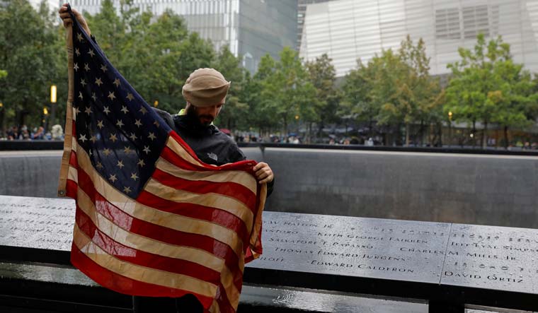 Jeremy Provancher, who served in Afghanistan with the Army 275 Ranger Regiment, carries a U.S. flag that was used in Afghanistan, as he visits the 9/11 Memorial | Reuters