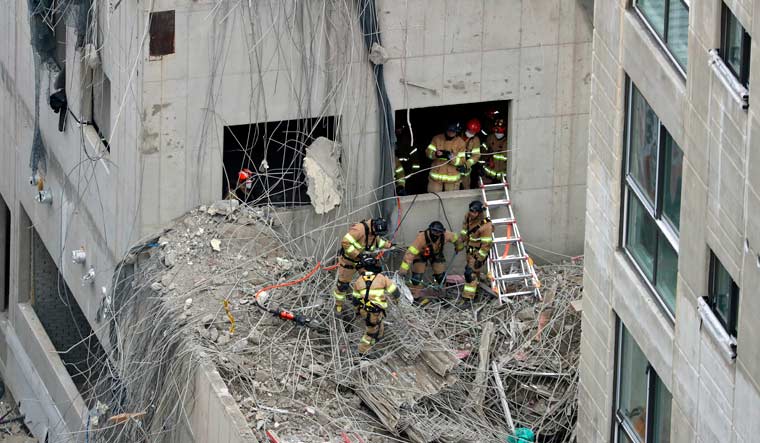 Rescuers search for workers who went missing in an apartment construction accident in Gwangju, South Korea, Thursday, Jan. 13, 2022 | AP