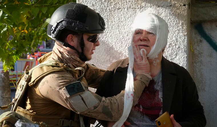FILE - An injured woman receives medical treatment at the scene of Russian shelling, in Kyiv, Ukraine, Oct. 10, 2022. Multiple explosions rocked Kyiv early Monday following months of relative calm in the Ukrainian capital. Kyiv Mayor Vitali Klitschko reported explosions in the city's Shevchenko district, a large area in the center of Kyiv that includes the historic old town as well as several government offices. (AP Photo/Efrem Lukatsky, File)