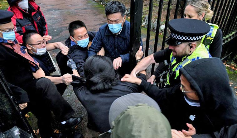 A man is pulled at the gate of the Chinese consulate after a demonstration against China's President Xi Jinping, in Manchester, Britain October 16, 2022 | Reuters