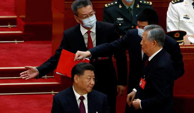 Former Chinese president Hu Jintao being escorted out of his seat during the closing ceremony of the 20th National Congress of the Communist Party of China in Beijing. Chinese President Xi Jinping is also seen |Reuters