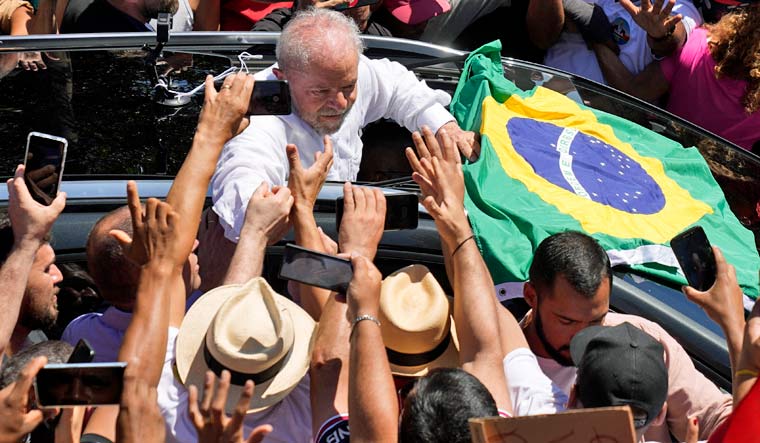 Luiz Inacio Lula da Silva holds hands with a supporter, Oct. 30, 2022 | AP