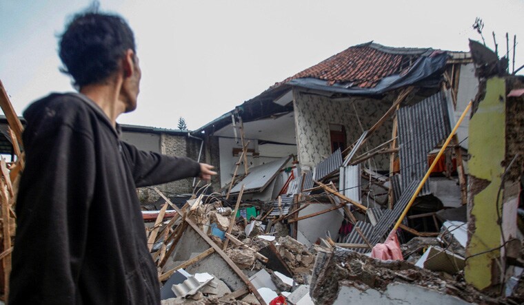 A local stands near houses damaged after earthquake hit in Cianjur, West Java province, Indonesia, November 21, 2022, in this photo taken by Antara Foto. Antara Foto/Yulius Satria Wijaya/ via REUTERS ATTENTION EDITORS - THIS IMAGE HAS BEEN SUPPLIED BY A THIRD PARTY. MANDATORY CREDIT. INDONESIA OUT. NO COMMERCIAL OR EDITORIAL SALES IN INDONESIA.