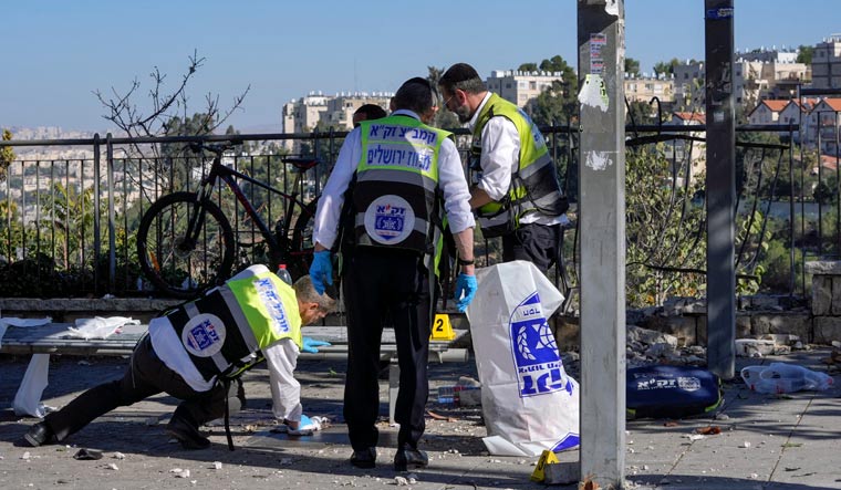 Members of Zaka Rescue and Recovery team clean blood from the scene of an explosion at a bus stop in Jerusalem, Wednesday, Nov. 23, 2022 | AP