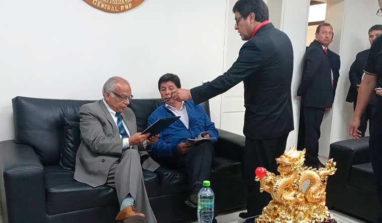 In this photo provided by Peru's police administration office, former President Pedro Castillo, second from left, and former Prime Minister Anibal Torres, far left, sit as prosecutor Marco Huaman stands at center inside a police station, where Castillo and Torres' status was not immediately clear, in Lima, Peru on Wednesday | AP