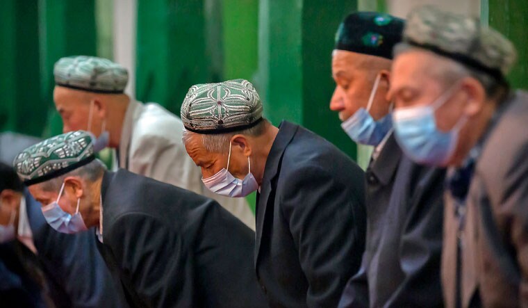 Uyghurs and other members of the faithful pray during services at the Id Kah Mosque in Kashgar in western China's Xinjiang Uyghur Autonomous Region | AP 