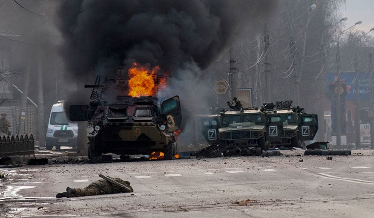 A Russian armored personnel carrier burns amid damaged and abandoned light utility vehicles after fighting in Kharkiv | AP