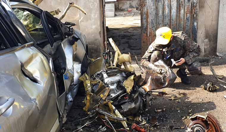 A military examiner inspects debris from the South Korean Air force's KT-1 trainer aircraft collision at a village in Sacheon | AP