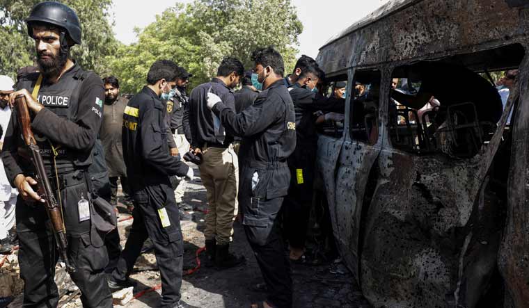 Members of a crime scene unit collect evidence from a van at the suicide bomb attack site in Karachi | Reuters