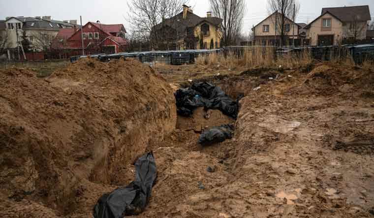 Bodies lie in a mass grave in Bucha, on the outskirts of Kyiv | AP