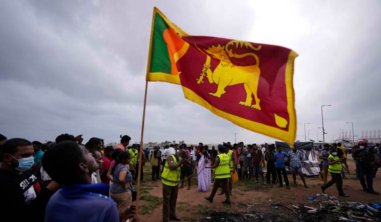 A Sri Lankan man holds a national flag during a protest in Colombo | AP