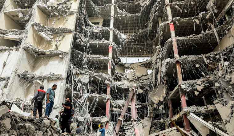 Debris hangs from the Metropol buildin,g a 10-story commercial building under construction, in the southwestern city of Abadan, Iran, Tuesday, May 24, 2022 | AP