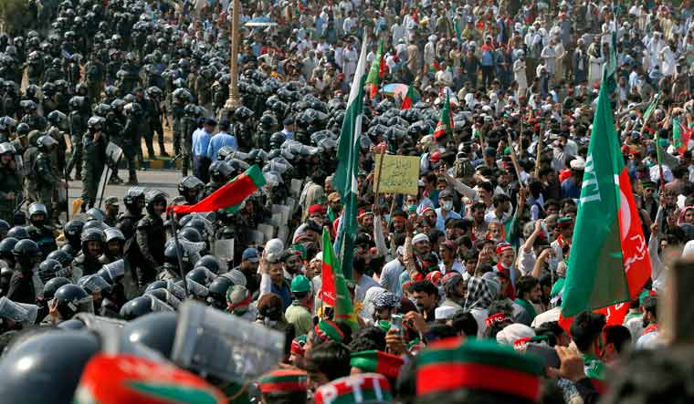 Supporters of Pakistan's defiant former Prime Minister Imran Khan chant slogans next to paramilitary soldiers stopping them to march towards parliament during an anti-government rally in Islamabad, Pakistan, Thursday, May 26, 2022 | AP