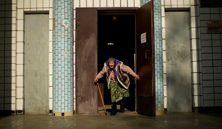 A woman, fleeing from an area near the front line in Donetsk, prepares to board a bus in Kurakhove, eastern Ukraine | AP