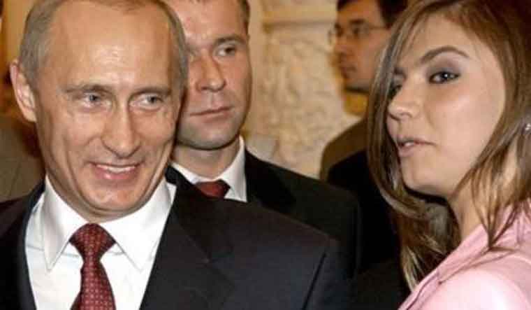 (FILE) Russian President Vladimir Putin (L) smiles next to Russian gymnast Alina Kabayeva during the meeting with the Russian Olympic team in Moscow's Kremlin in 2004 | Reuters