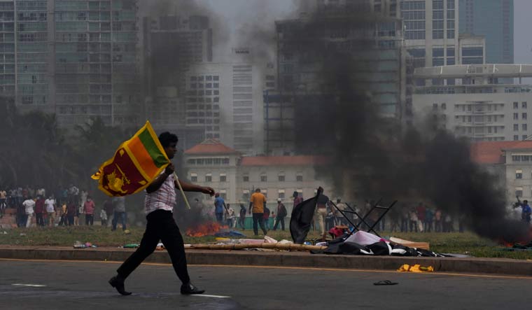 A Sri Lankan government supporter carries a national flag during a protest in Colombo | AP