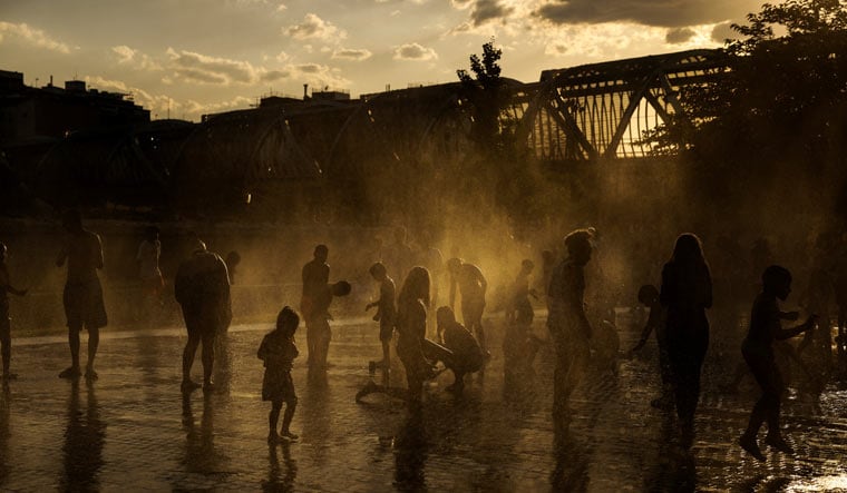 People cool off at a fountain in Madrid Rio Park during the first heatwave of the year in Madrid, Spain, June 11, 2022 | Reuters